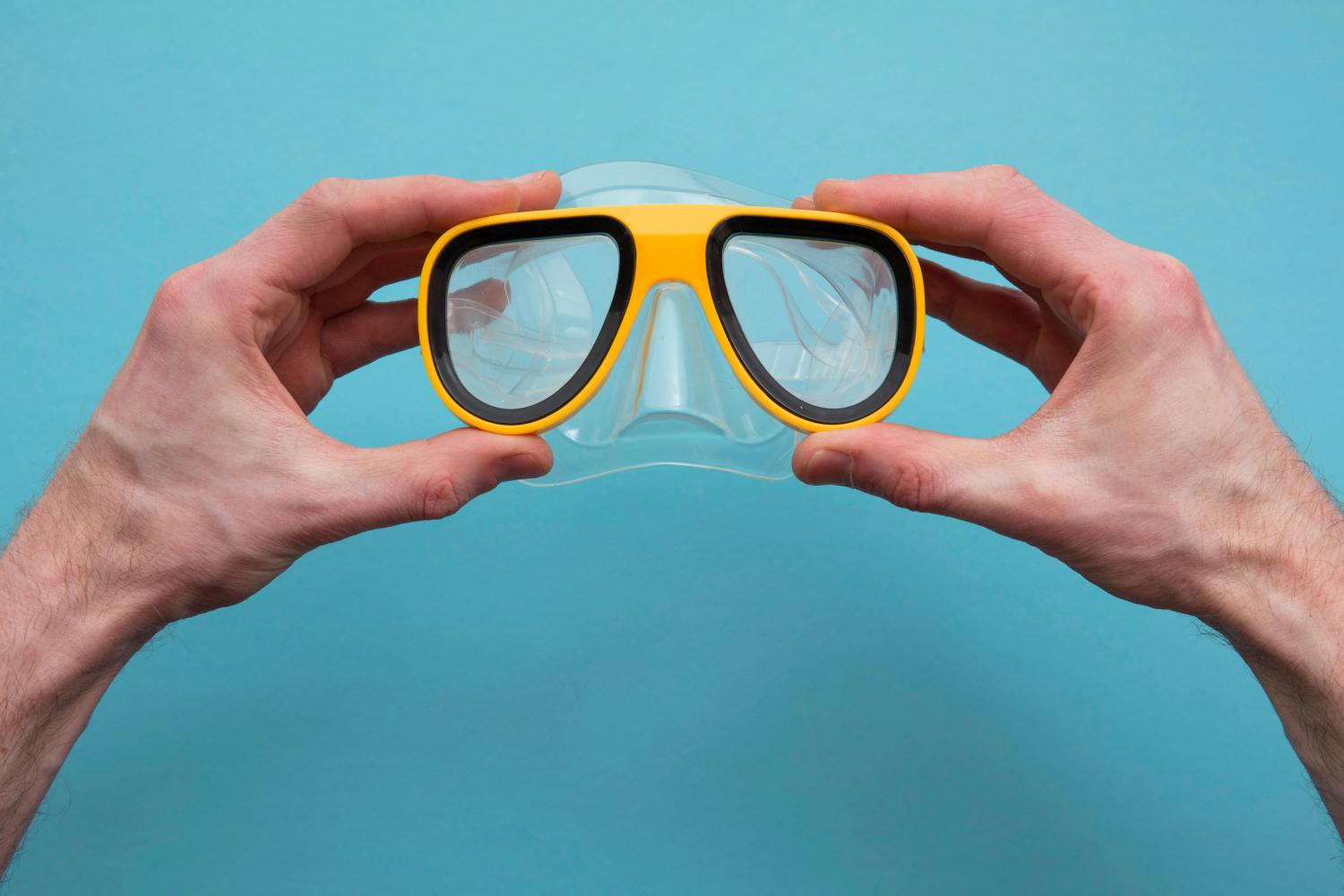 a hand holding a snorkel mask